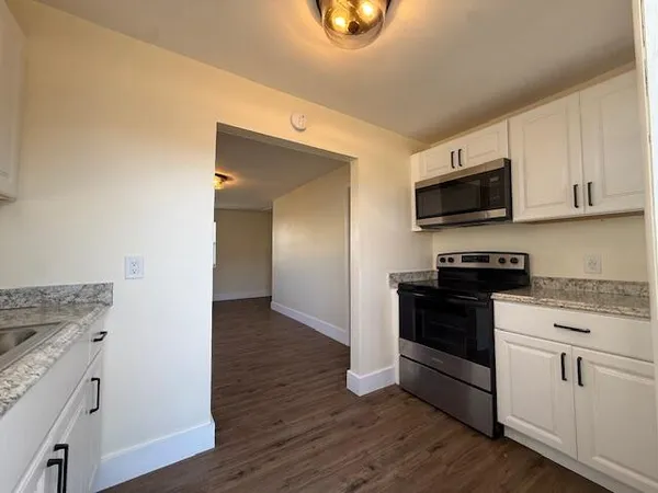 a kitchen with granite countertop a stove and a microwave