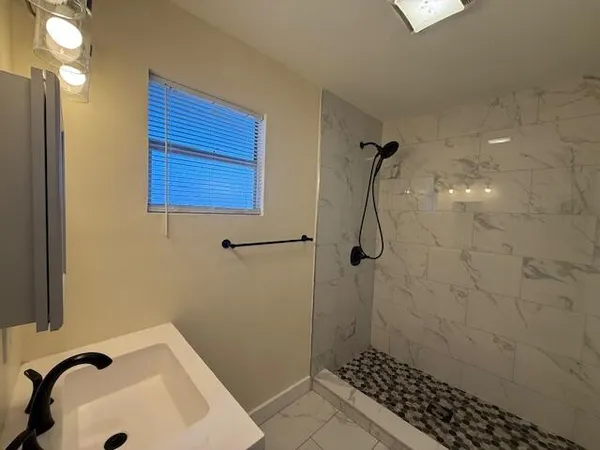 a bathroom with a sink a toilet and shower