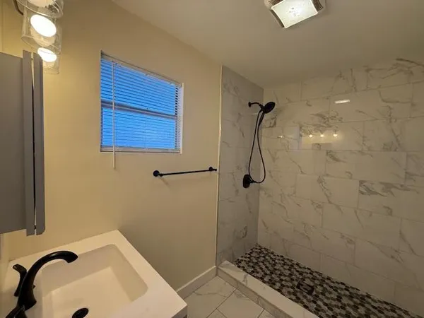a bathroom with a sink a toilet and shower