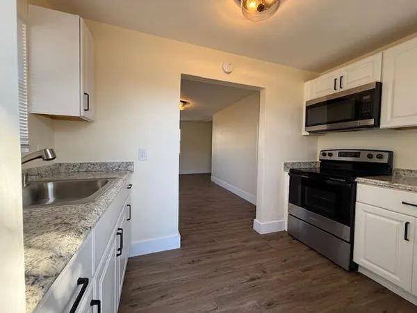 a kitchen with stainless steel appliances granite countertop a sink and a stove top oven