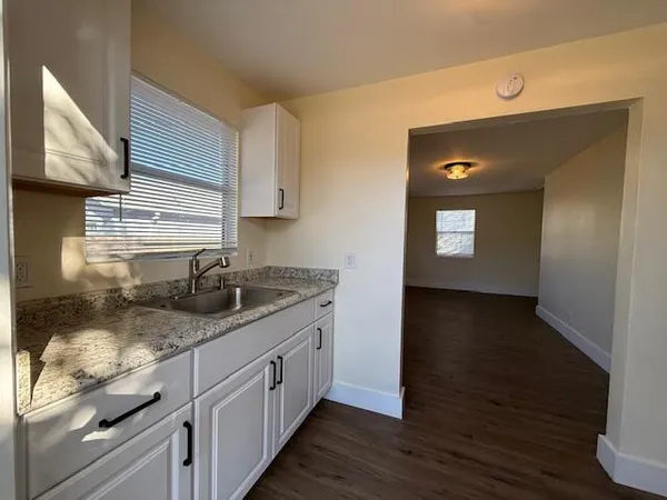 a kitchen with a sink a stove and cabinets