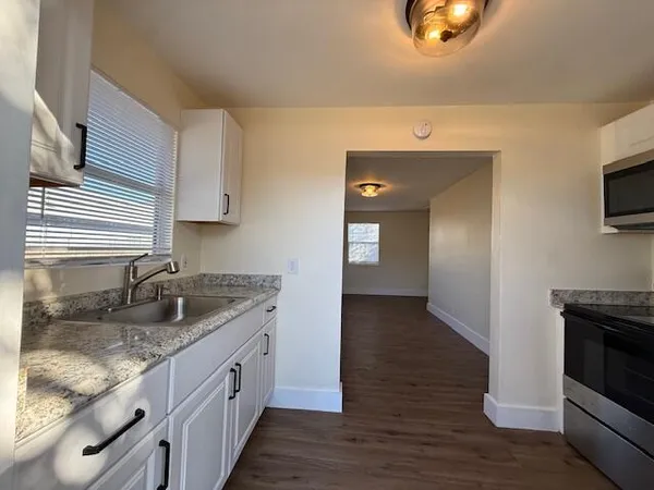 a kitchen with granite countertop a sink and a stove top oven