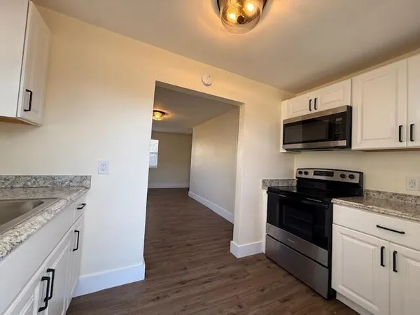a kitchen with granite countertop a stove top oven and sink