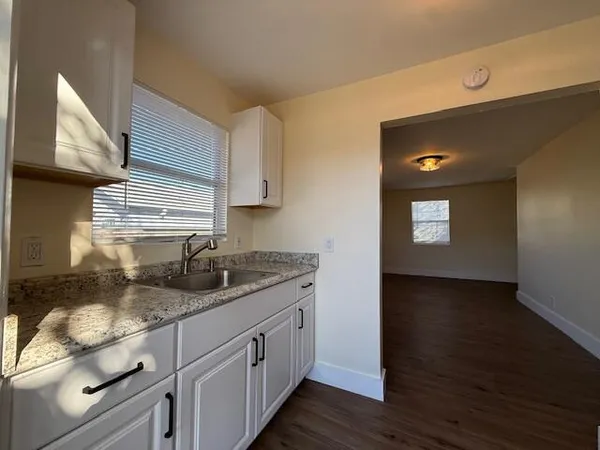 a kitchen with granite countertop a sink and a stove
