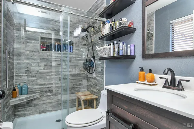 a bathroom with a sink a toilet and shower