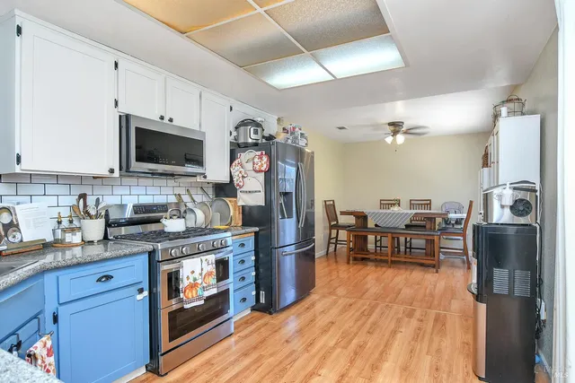 a kitchen with stainless steel appliances granite countertop a refrigerator stove microwave and sink