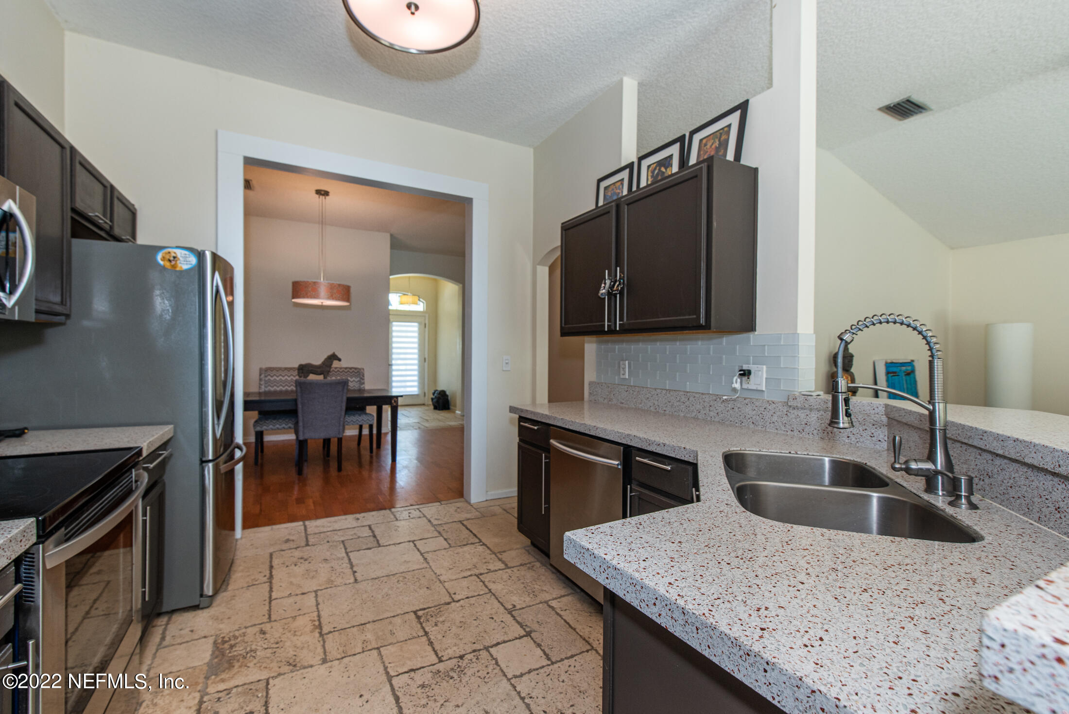 1741 Keswick Road St. Augustine, FL 32084 - Photo 9 of 42 a kitchen with granite countertop a sink a stove and refrigerator