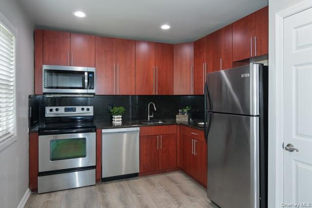 40 Middleton Road, Unit LA02 Bohemia, NY 11716 - Photo 2 of 6 a kitchen with granite countertop a refrigerator stove and microwave