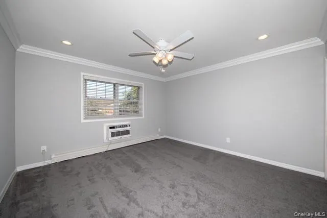 an empty room with chandelier fan and windows