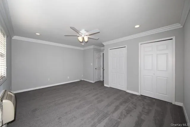 an empty room with a ceiling fan and a window