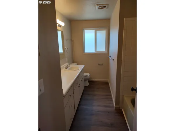 a hallway with white doors wooden floor and fence