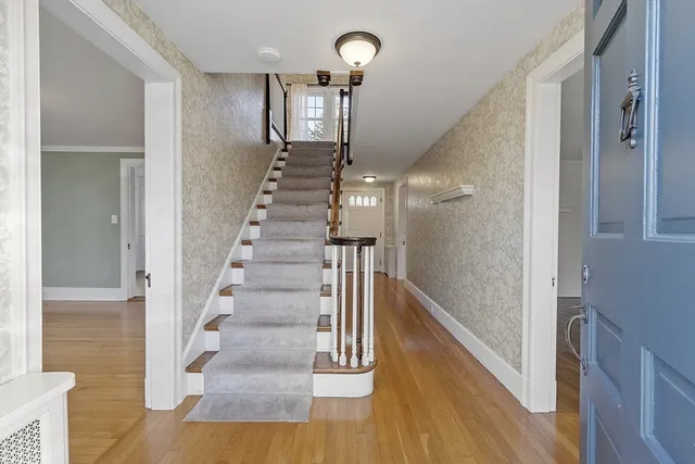 a view of an entryway with wooden floor and a empty room
