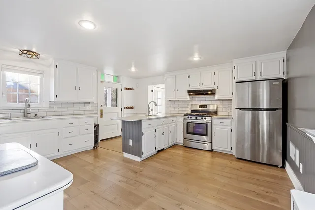 a kitchen with white cabinets and stainless steel appliances