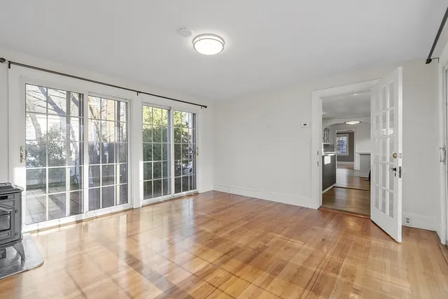 a view of an empty room with glass door and windows