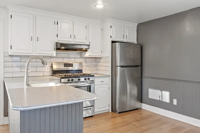 a kitchen with a refrigerator stove and wooden cabinets