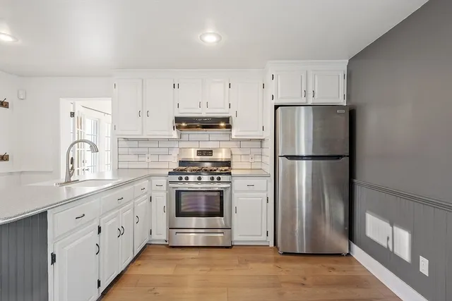 a kitchen with stainless steel appliances a refrigerator sink and cabinets