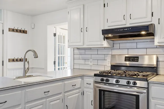 a kitchen with granite countertop a stove and a sink