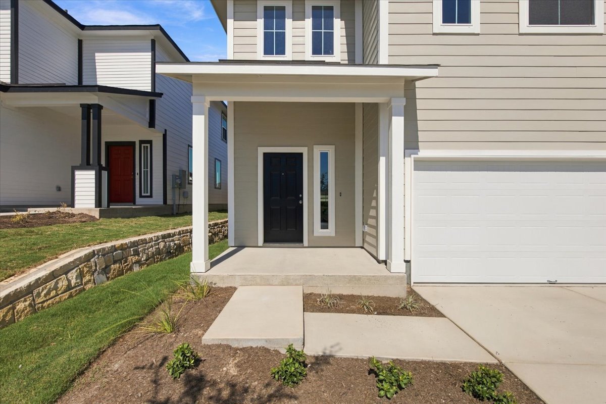 A welcoming front porch leads to the entrance of this modern two-story home.