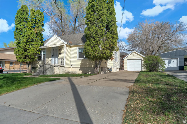 744 North 500 East Logan, UT 84321 - Photo 1 of 29 View of front of home featuring an outbuilding, a front lawn, a detached garage, and a shingled roof