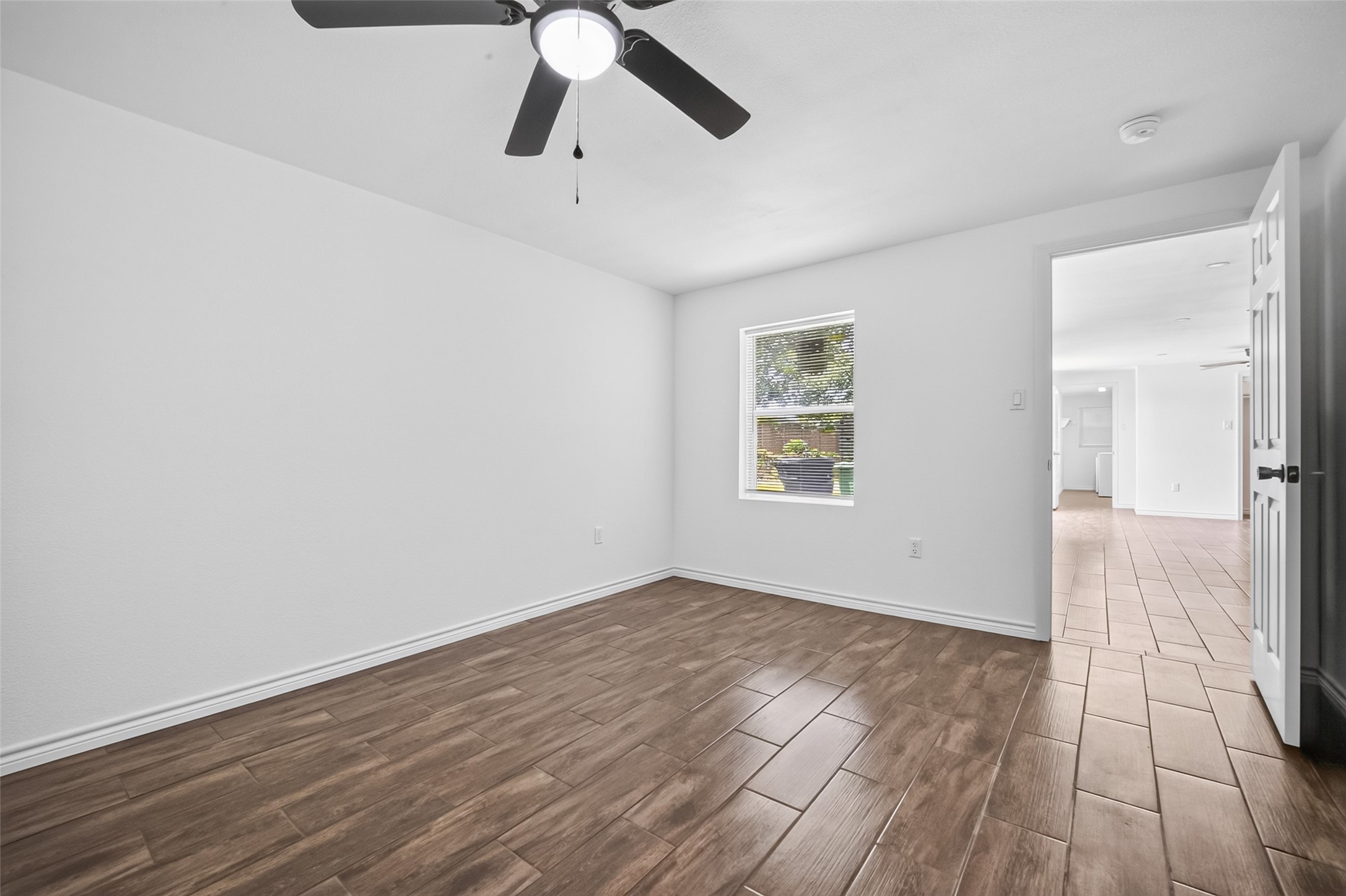 3530 Rosedale Street Houston, TX 77004 - Photo 32 of 50 Spacious guest bedroom with beautiful wood-style flooring and ample natural light, perfect for comfort and relaxation.