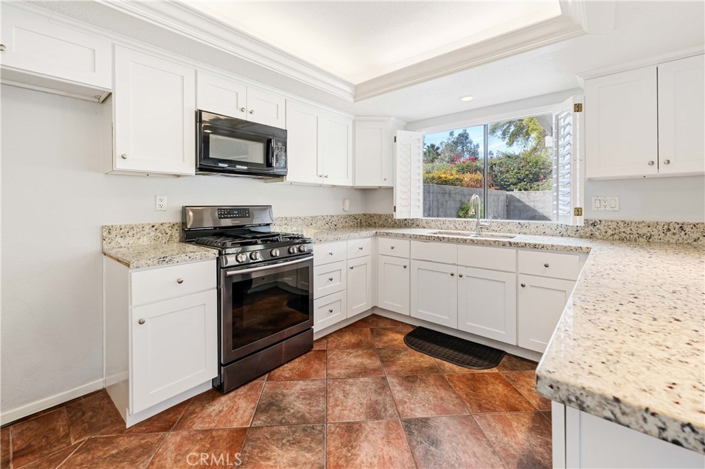 5855 Sunset Ranch Drive Riverside, CA 92506 - Photo 5 of 36 a kitchen with white cabinets appliances and a window
