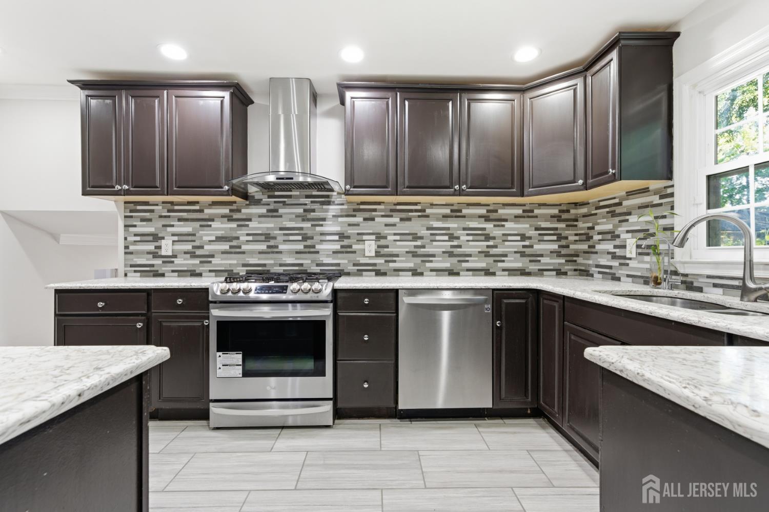 5 McKinley Street Edison, NJ 08820 - Photo 13 of 38 a kitchen with stainless steel appliances kitchen island granite countertop wooden cabinets and a sink