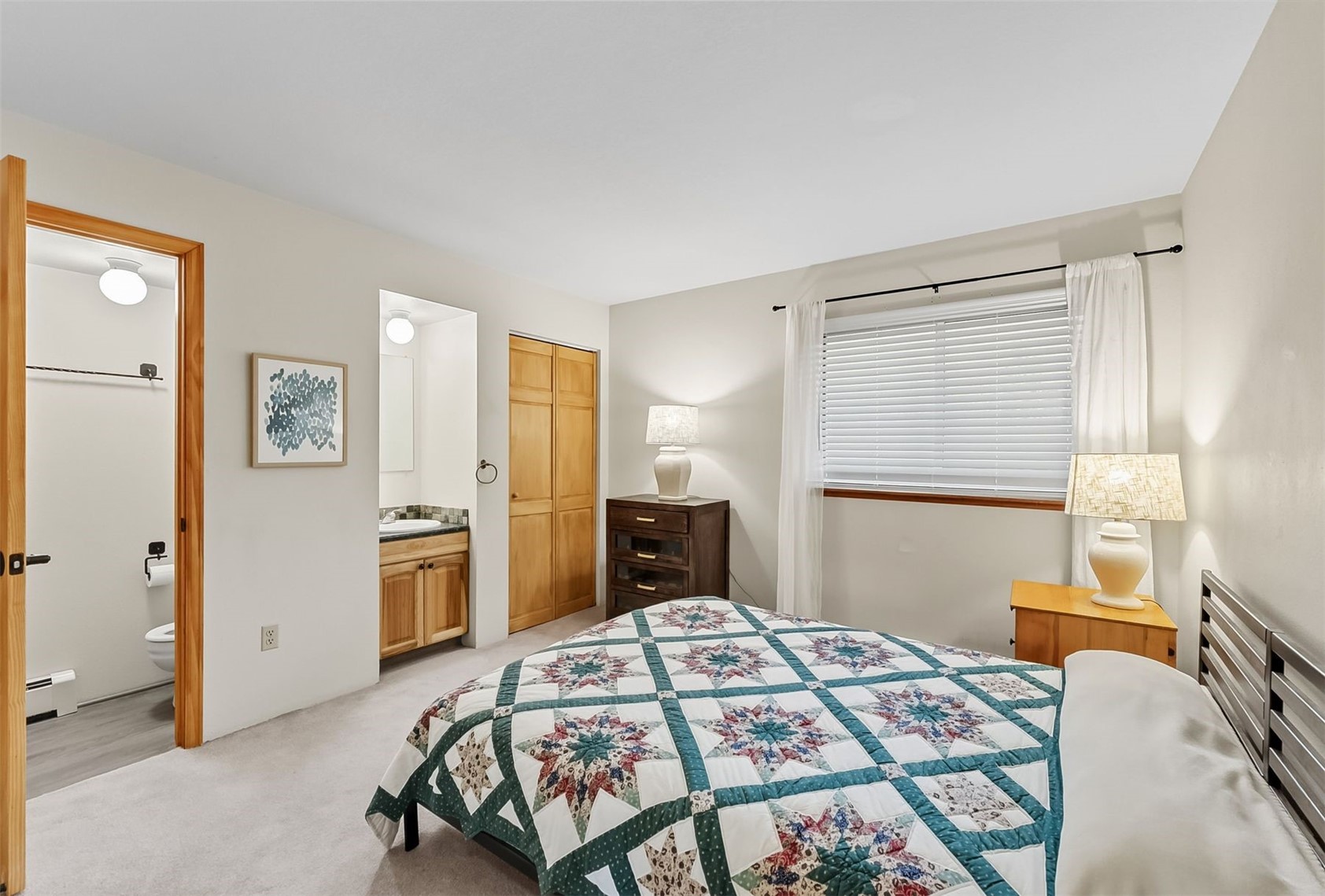 9849 Ryan Gulch Road, Unit 203 Silverthorne, CO 80498 - Photo 17 of 35 Bedroom featuring a closet, light carpet, baseboard heating, and ensuite bathroom