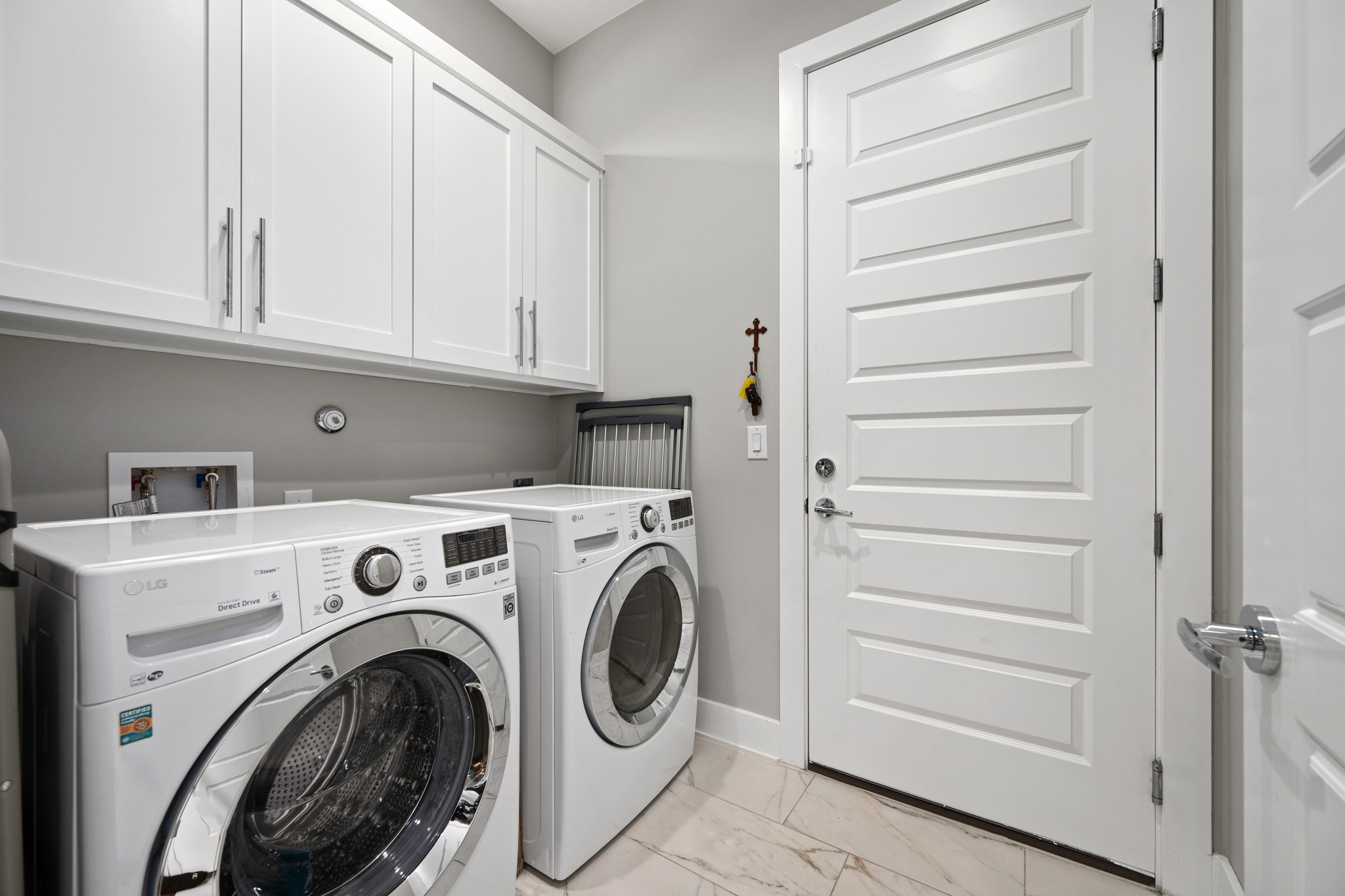 1103 Saucedo Street, Unit 1 Austin, TX 78721 - Photo 26 of 40 Functional laundry room equipped with upper cabinetry and a durable tile floor.