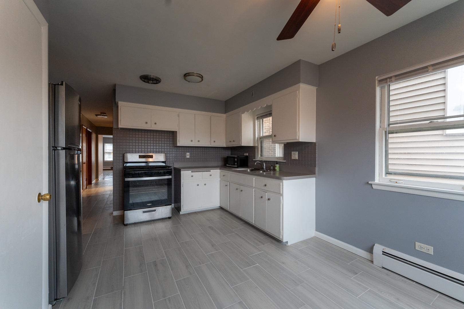 1440 Maple Avenue, Unit 1 Berwyn, IL 60402 - Photo 19 of 23 a kitchen with granite countertop white cabinets and stainless steel appliances