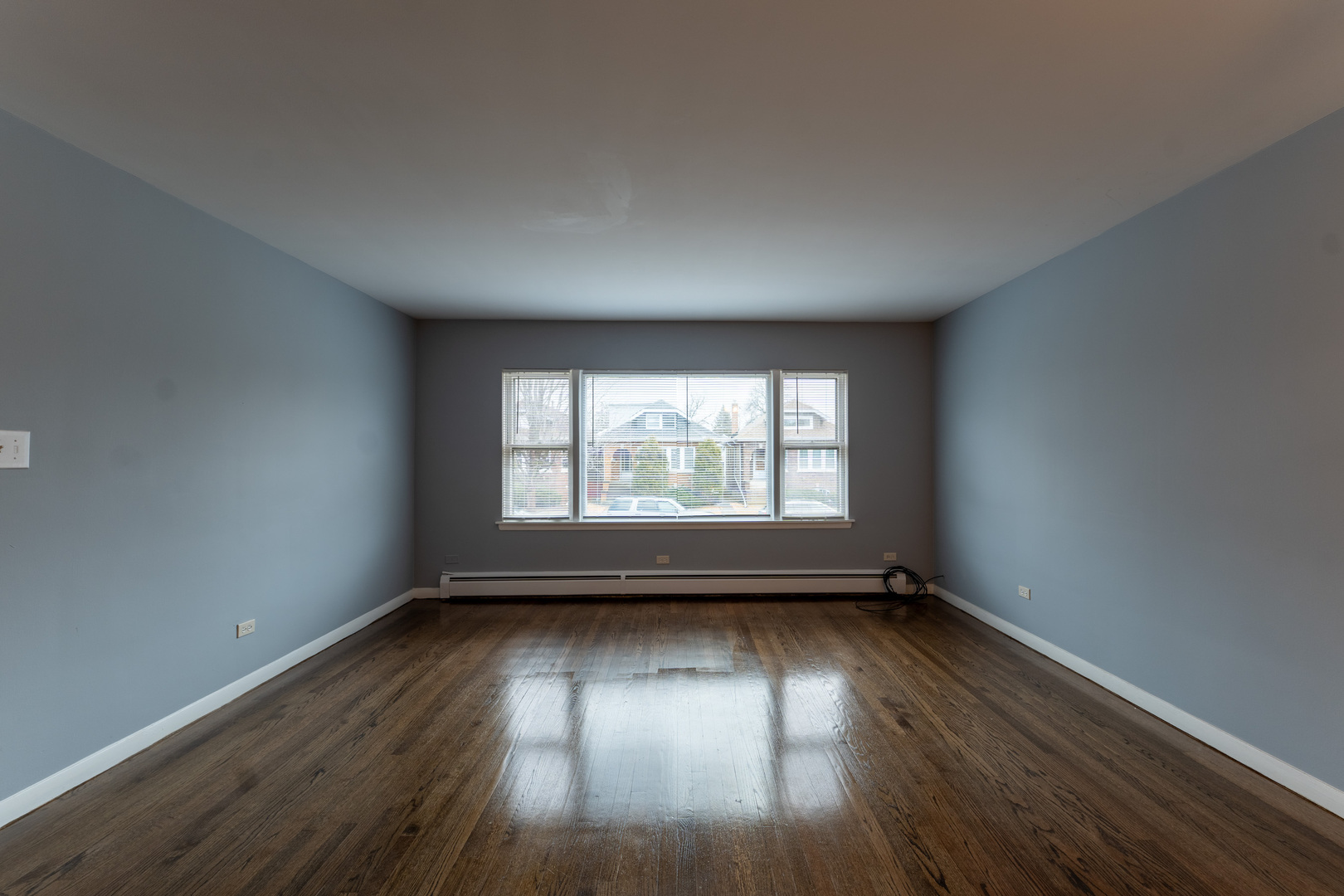 1440 Maple Avenue, Unit 1 Berwyn, IL 60402 - Photo 5 of 23 an empty room with wooden floor and windows