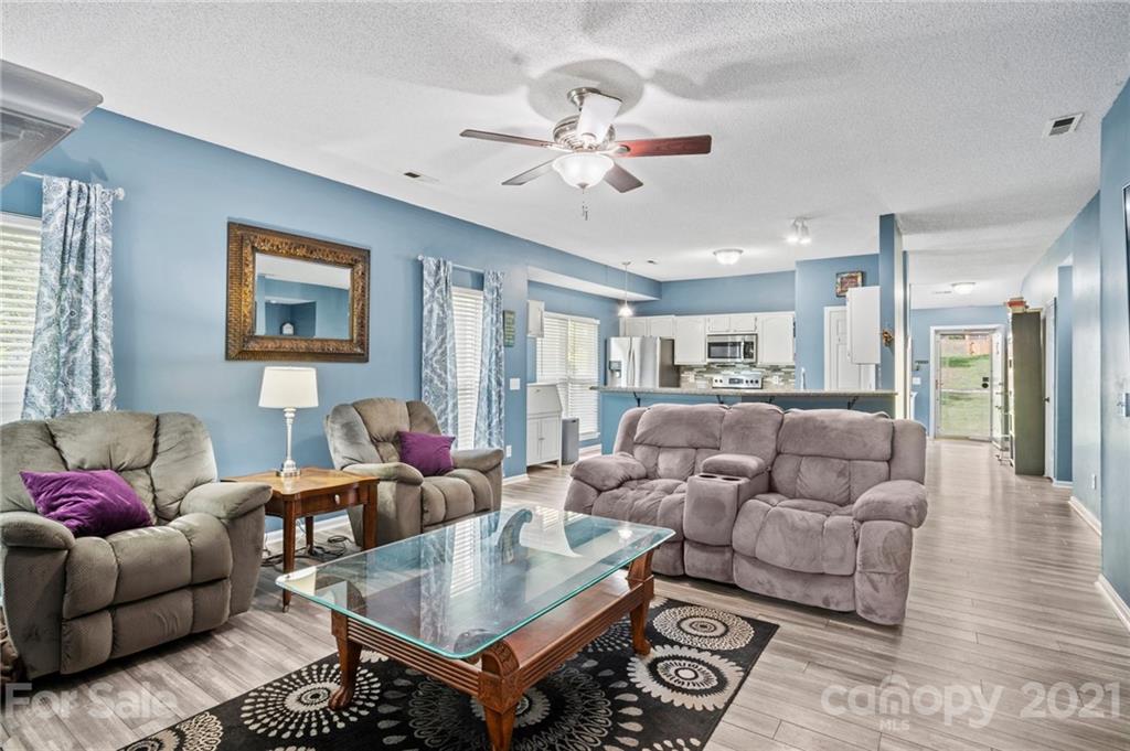 11204 Clayford Ridge Charlotte, NC 28215 - Photo 10 of 37 a living room with furniture and a chandelier