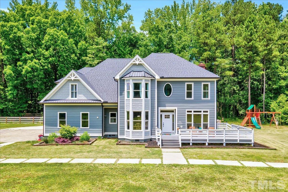 a front view of a house with swimming pool and porch with furniture