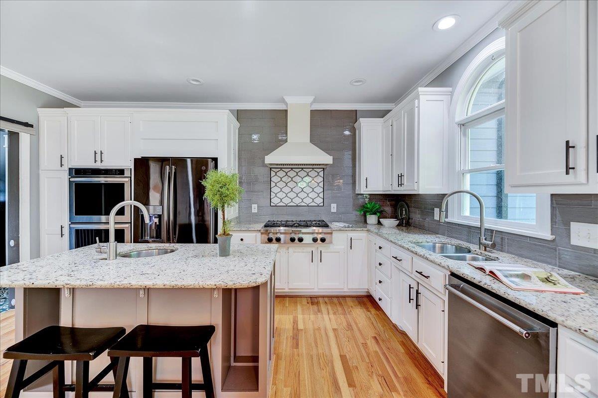 7033 Daniel Road Wake Forest, NC 27587 - Photo 21 of 63 a kitchen with stainless steel appliances granite countertop a stove top oven a sink dishwasher and cabinets with wooden floor