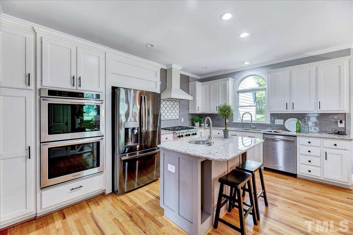 7033 Daniel Road Wake Forest, NC 27587 - Photo 22 of 63 a kitchen with a sink stainless steel appliances and white cabinets