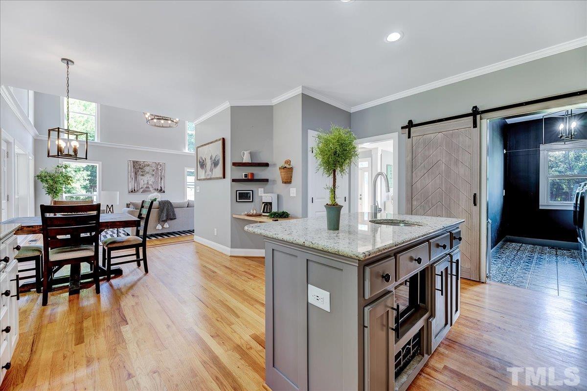 7033 Daniel Road Wake Forest, NC 27587 - Photo 23 of 63 a kitchen with granite countertop a table chairs stove and wooden floor