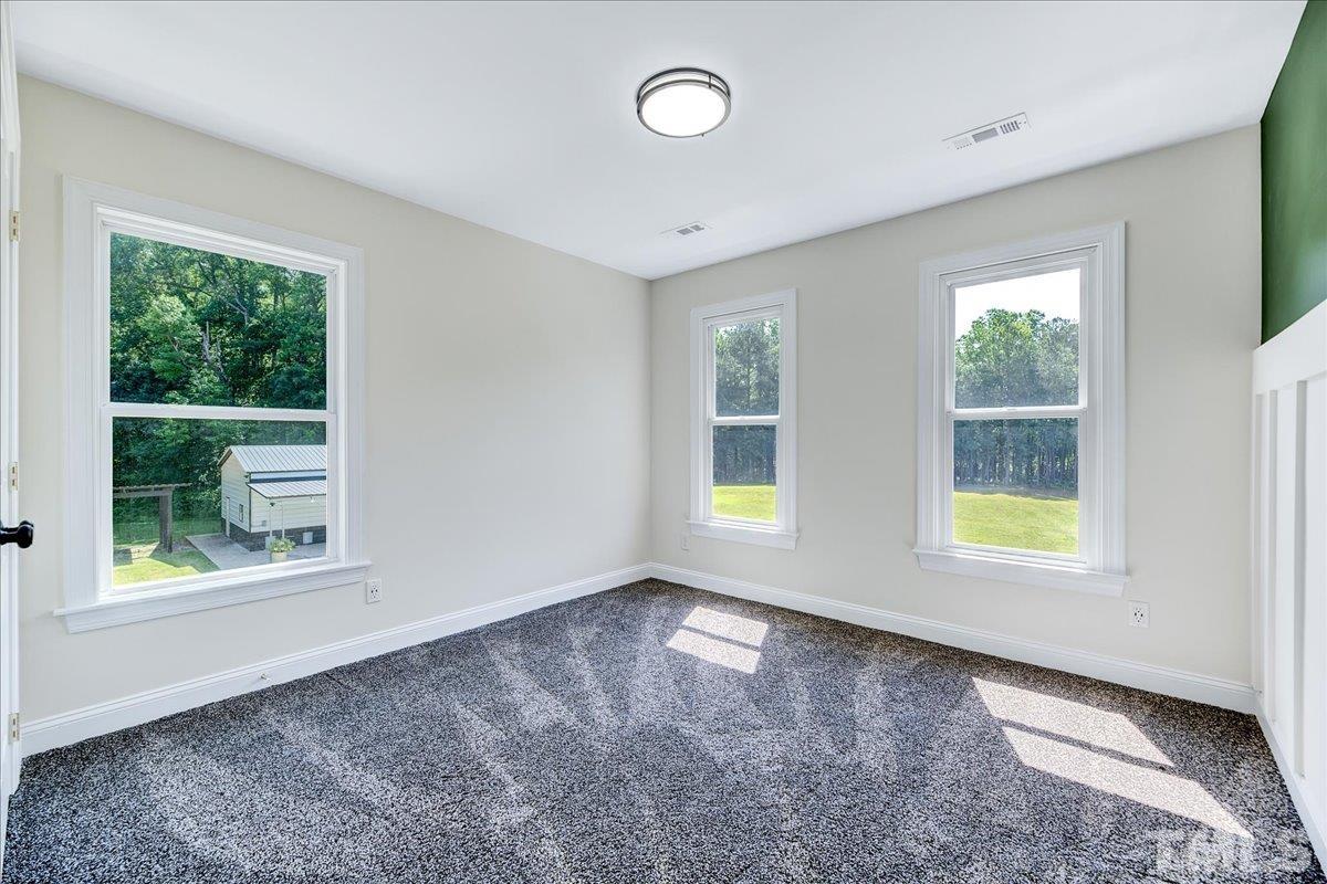 7033 Daniel Road Wake Forest, NC 27587 - Photo 27 of 63 a view of an empty room with a window and a kitchen