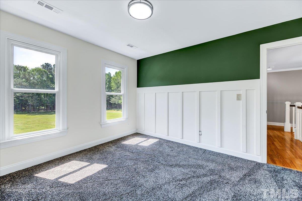 7033 Daniel Road Wake Forest, NC 27587 - Photo 28 of 63 a view of an empty room with window and hardwood floor