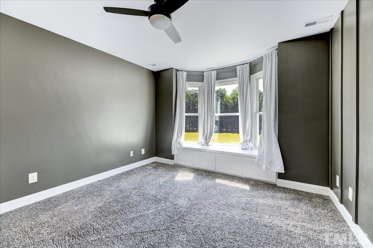 7033 Daniel Road Wake Forest, NC 27587 - Photo 32 of 63 a view of an empty room with a window and a ceiling fan