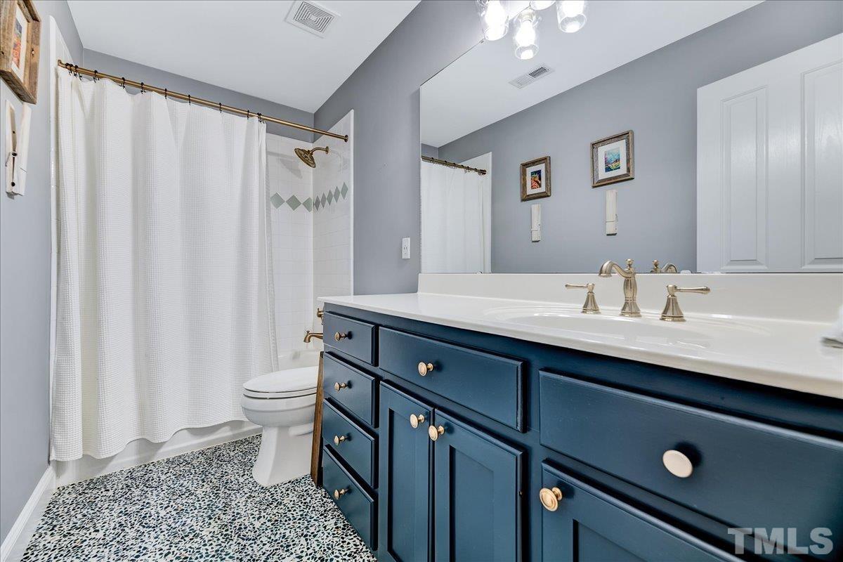 7033 Daniel Road Wake Forest, NC 27587 - Photo 36 of 63 a bathroom with a double vanity sink toilet and a mirror