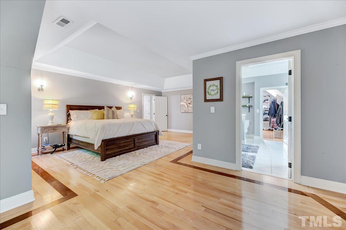 7033 Daniel Road Wake Forest, NC 27587 - Photo 42 of 63 a spacious bedroom with a bed and wooden floor