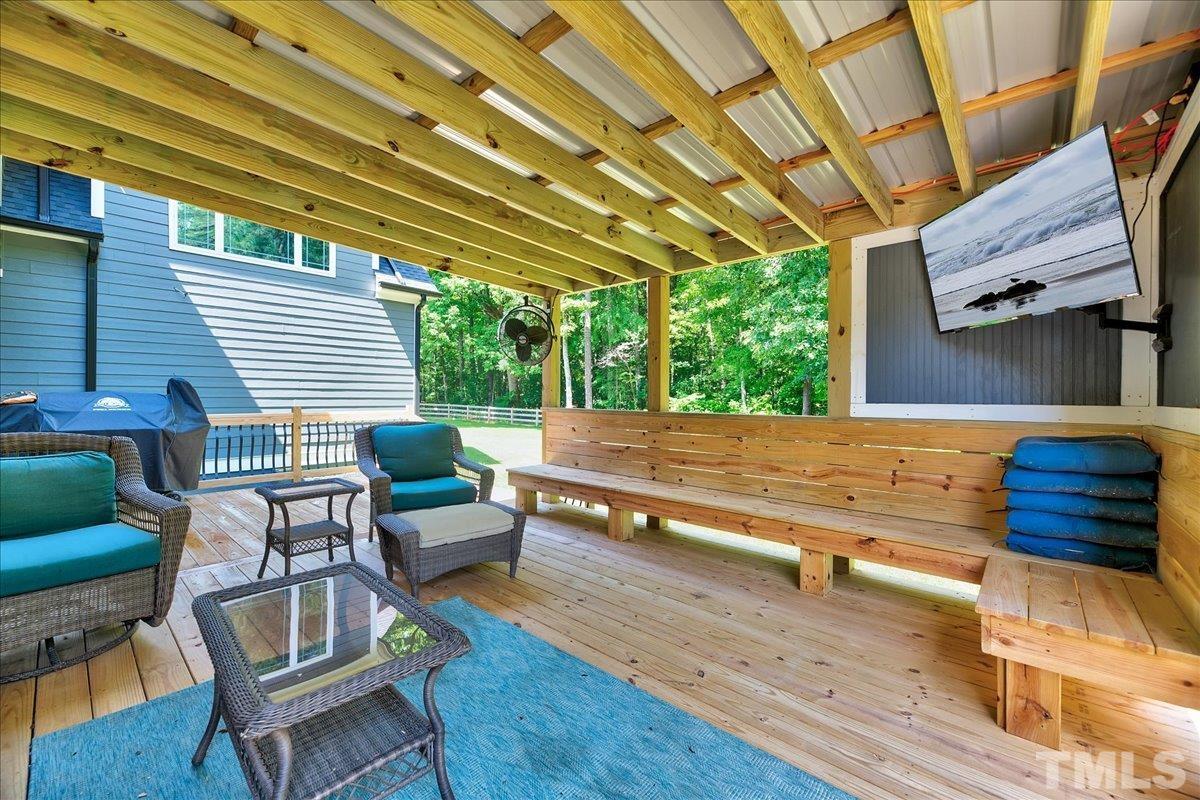 7033 Daniel Road Wake Forest, NC 27587 - Photo 49 of 63 a view of a patio with table and chairs with wooden floor and fence