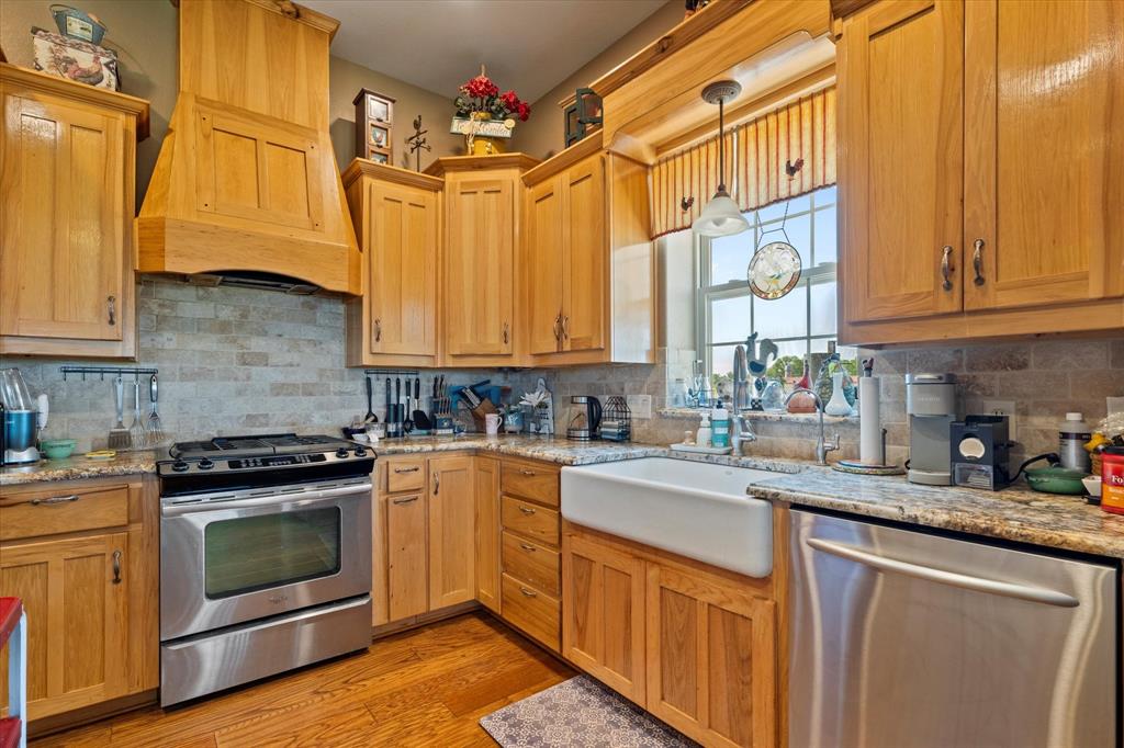 2801 Agnes Circle Springtown, TX 76082 - Photo 17 of 40 a kitchen with stainless steel appliances granite countertop a sink a stove and cabinets