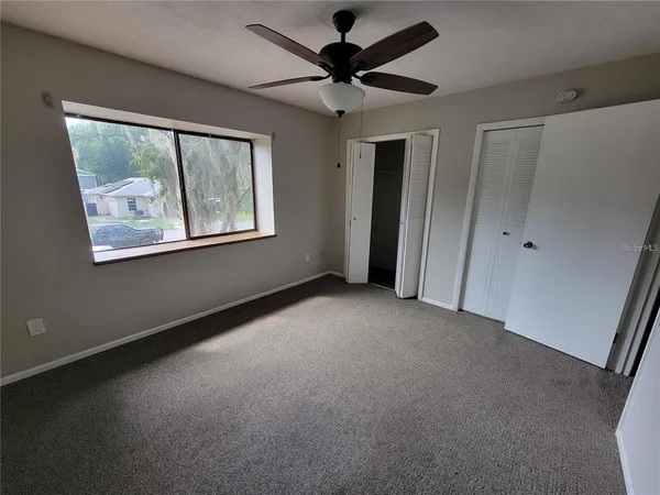 a view of a livingroom with a ceiling fan and a window