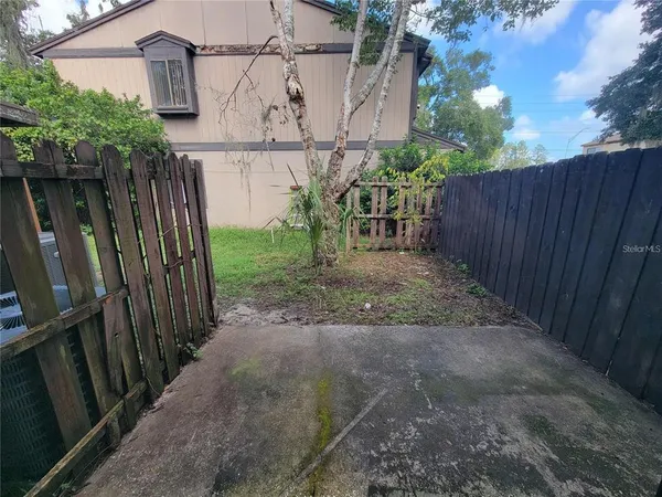 a view of a backyard with wooden fence