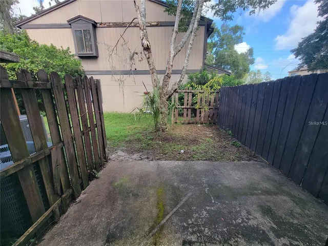 a view of a backyard with wooden fence
