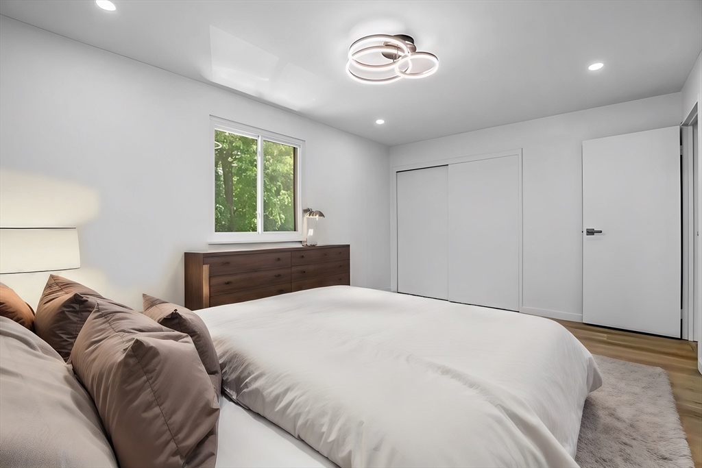 75 Nicholas Road, Unit K Framingham, MA 01701 - Photo 12 of 24 a bed room with a bed and a chandelier
