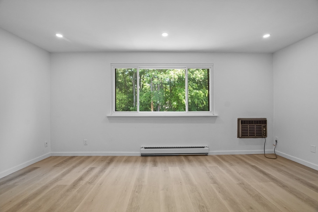 75 Nicholas Road, Unit K Framingham, MA 01701 - Photo 16 of 24 a view of an empty room with wooden floor and a window