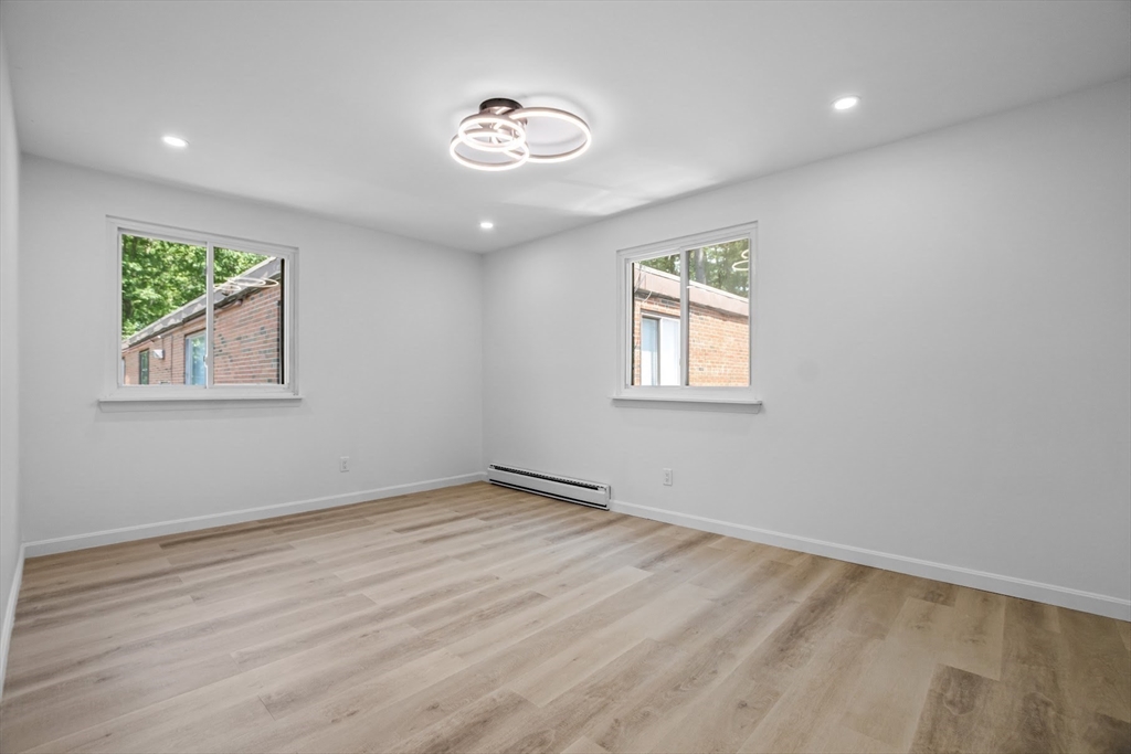 75 Nicholas Road, Unit K Framingham, MA 01701 - Photo 18 of 24 a view of an empty room with wooden floor and a window