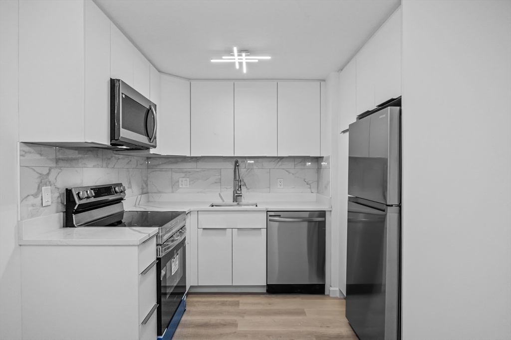 75 Nicholas Road, Unit K Framingham, MA 01701 - Photo 3 of 24 a kitchen with stainless steel appliances granite countertop a stove a refrigerator and a sink
