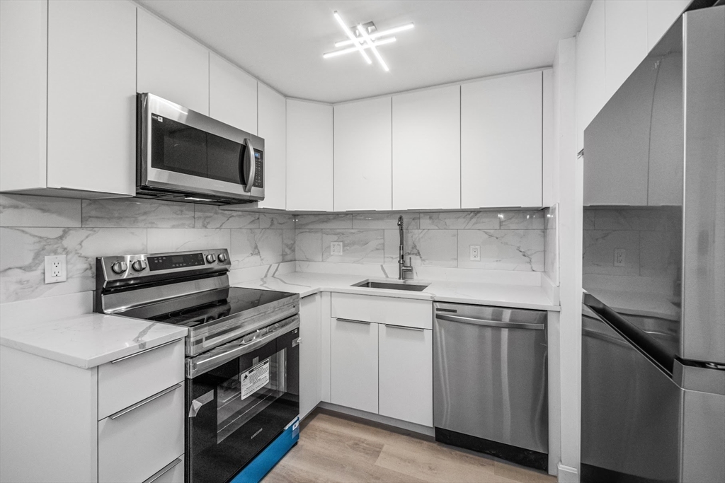 75 Nicholas Road, Unit K Framingham, MA 01701 - Photo 4 of 24 a kitchen with stainless steel appliances granite countertop a sink stove and microwave